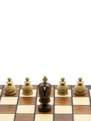 Obraz na płótnie Canvas Leadership Concept: Black King Chess Piece With White Pawns On A Wooden Chess Board, White Background