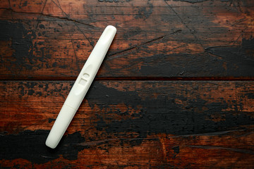 ready to use Pregnancy test kit on a wooden desk
