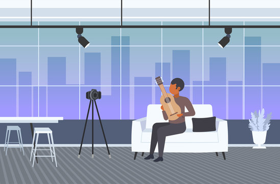 music blogger playing guitar live streaming musical blog concept african american man recording video using camera on tripod modern living room interior horizontal full length vector illustration