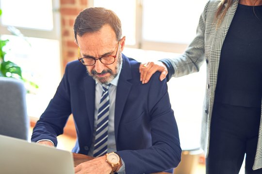 Two middle age business workers working together. Man suffering sexual harassment at the office