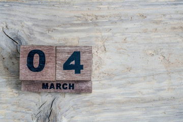 cube calendar for march on wooden background with copy space