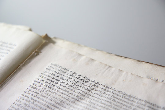 Dettaglio di pagine di antico libro con capolettera nel testo. Messa a fuoco selettiva