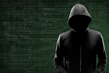 Computer hacker in mask and hoodie over abstract binary background. Obscured dark face. Data thief,...
