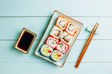 japanese sushi food. Rolls with tuna, salmon, shrimp, crab and vegetables. Top view of assorted sushi. Rainbow sushi roll on wooden background. Flat lay
