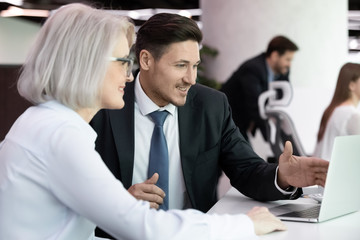 Smiling businessman showing project presentation to mature client.