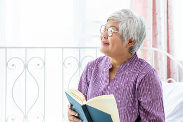 Happy elderly senior woman female lady enjoy reading book