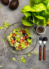Salad with fresh vegetables olives tomatoes red onion greek cheese feta and olive oil. Top view.