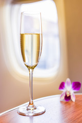 A glass of wine placed on the table in the passenger cabin on the plane