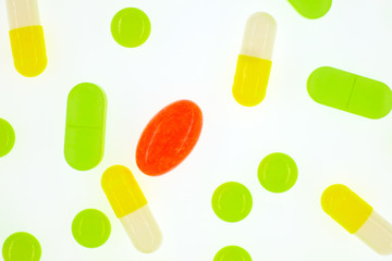 A lot of multi-colored medical pills top view close-up isolated on a white background. Vertical frame