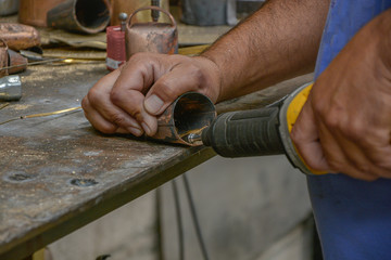 Hands cleaning cowbells for manufacture, forging