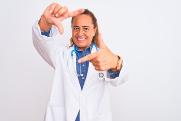 Middle age mature doctor woman wearing stethoscope over isolated background smiling making frame with hands and fingers with happy face. Creativity and photography concept.