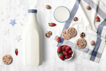 Farm milk bottle composition mockup on white wooden background, with cookies, berries and blank label to place your design