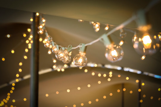 Low Angle View Of Illuminated Light Bulbs On String During Party