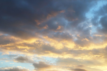 Fototapeta premium Sunset in the evening sky with golden clouds in the evening. Natural background for later design. Prediction of weather on the circulation of water in the atmosphere. Romantic mood