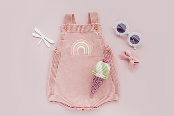 Pink knitted bodysuit with toy ice cream and sunglasses. Set of baby clothes and accessories...