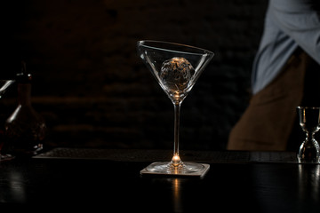 Tall big martini glass unusual form with an ice ball