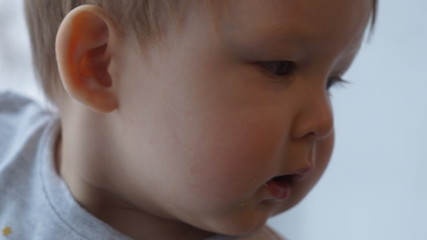 Face of a 1 year old boy in close-up on a light background