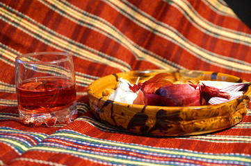 wine in a glass goblet and vegetables on a plate on a red tablecloth, still life