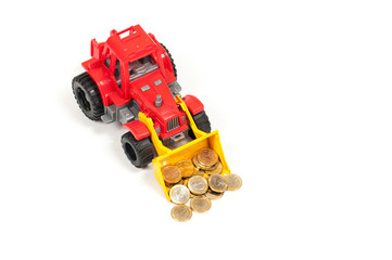 twenty fifty cents and one Euro coins in the bucket of a toy red bulldozer on a white background...