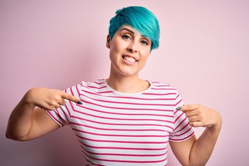 Young beautiful woman with blue fashion hair wearing casual striped t-shirt looking confident with...