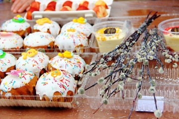 Easter cakes, willow branches, Easter curd on the background of eggs and woman hand. Consecration of festive food with Holy water in Christianity, preparation for the Orthodox holiday