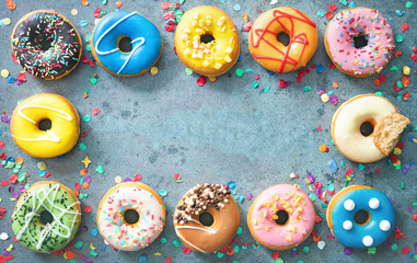 Festive carnival or birthday frame from various colourful donuts