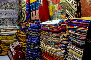 Moroccan carpets with vibrant colors for sale in the narrow street of Rabat in Morocco with selective focus.