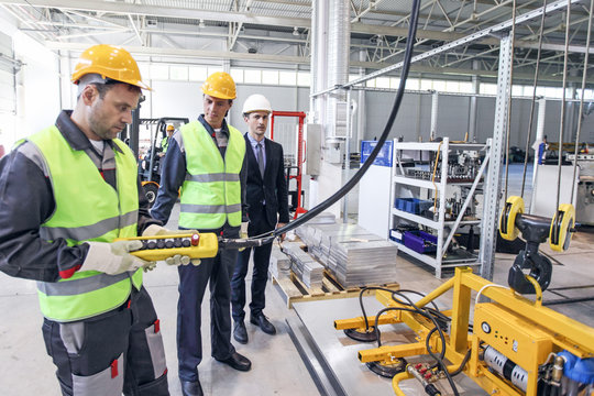 Workers And Electro Magnets Lifting Steel Plate