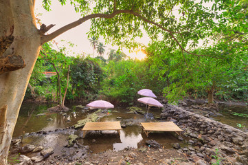 Cafe with Thai style wooden tables in the waterfall.