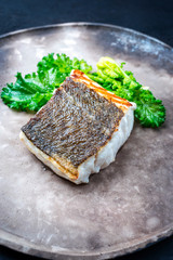 Gebratenes Skrei Kabeljau Fish Filet mit Stängelkohl als closeup auf einem Modern Design Teller