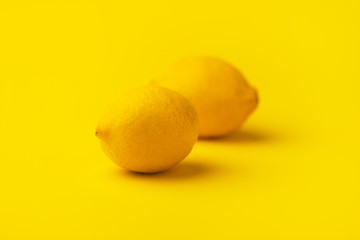 whole ripe lemon citrus fruits on yellow background