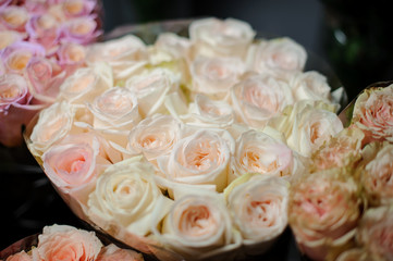Beautiful bouquet of tender creamy color roses in the transparent wrapping paper
