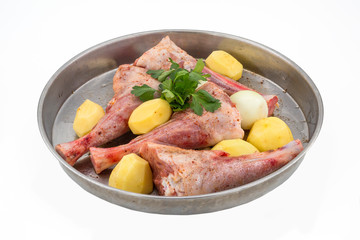 Lamb shank kebab on tray and potato onions around