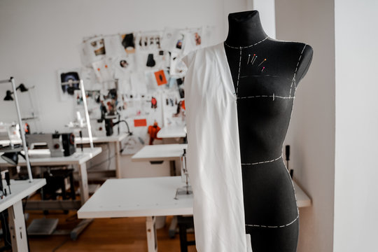 Mannequin with fabric on the shoulder and stuck pins into the fabric in design studio for sewing and tailoring, special education concept