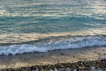 sea landscape is a pebbly beach with waves in white foam
