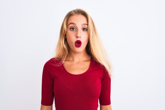 Young beautiful woman wearing red t-shirt standing over isolated white background afraid and shocked with surprise expression, fear and excited face.