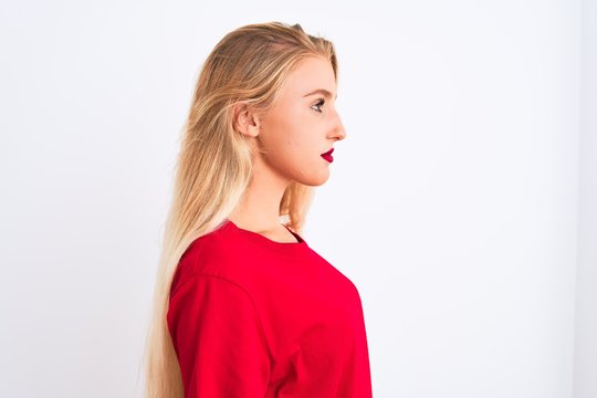 Young beautiful woman wearing red casual t-shirt standing over isolated white background looking to side, relax profile pose with natural face with confident smile.