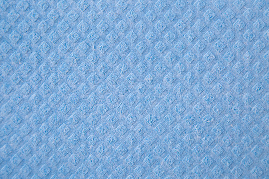 Blue background with a pattern of small diamonds made of polymer material. Backgrounds, structure, design.