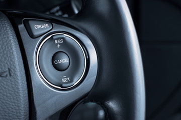 Cruise control button switch on steering wheel in a luxury car,automotive part concept.
