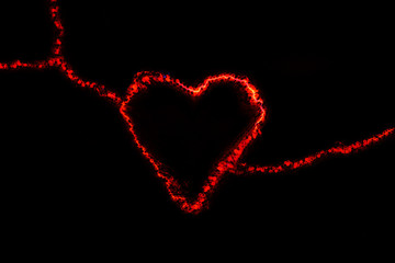 Red electric discharge in the form of a heart on a black background. Greeting card for valentines day. Bright light effect. The concept of relationships and love.