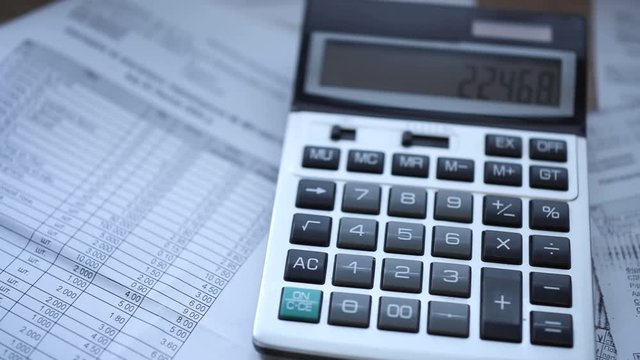 Next to the calculator are chaotically scattered accounting documents filled in Ukrainian. The smooth movement of the camera.