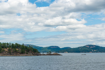 View over inlet, ocean and island with boat and mountains in beautiful British Columbia. Canada.