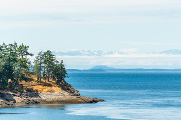 View over inlet, ocean and island with boat and mountains in beautiful British Columbia. Canada.