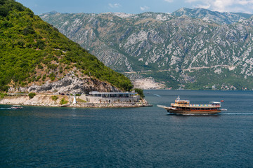 Bay of Kotor, also known as Kotorska Boka, during a quiet summer afternoon with mountains reflecting in the waters of the Adriatic sea.