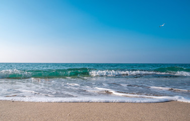 Seascape. Waves running on the sandy shore. Shore of the sea or ocean on a nice day. Vacation and relaxation by the sea.