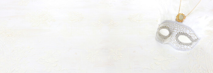 Obraz na płótnie Canvas Photo of elegant and delicate Venetian mask over white wooden background