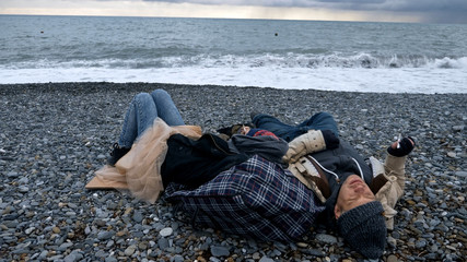 homeless couple, man and woman, staying overnight by the sea