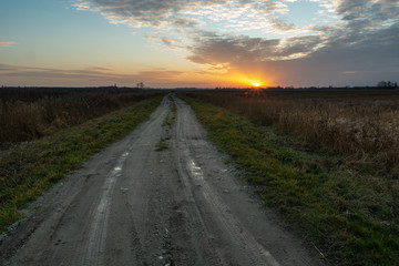 Straight and long dirt road and sunset, Srebrzyszcze, Poland