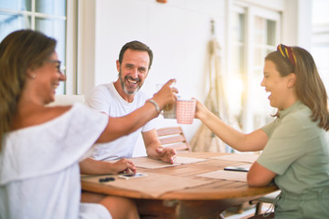 Beautiful family sitting on terrace drinking cup of coffee speaking and smiling