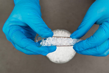 Plastic granules . Polyethylene pellets and hands with gloves. Quality control of plastic in the...